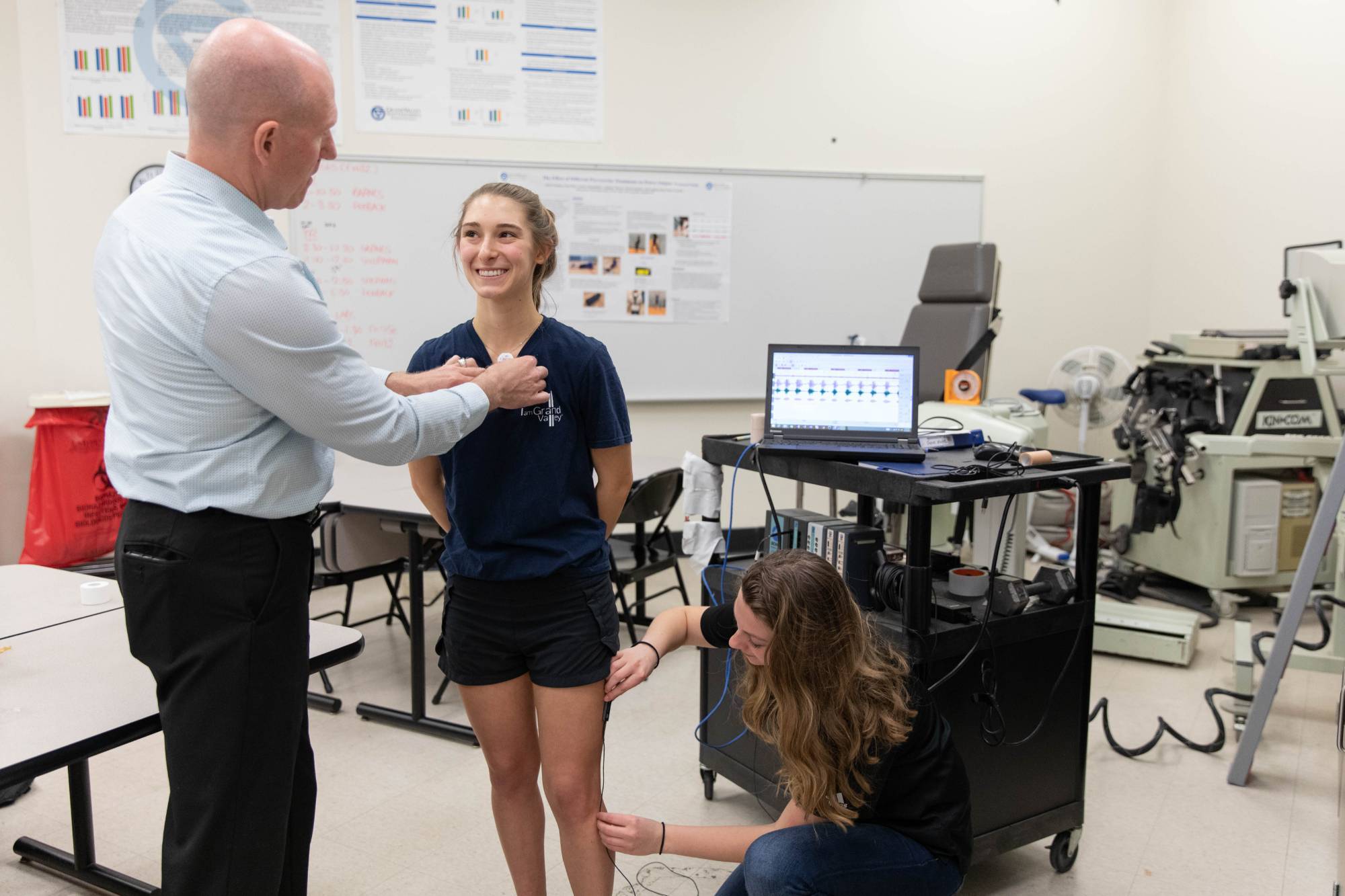 Professor prepping student for electromyography testing